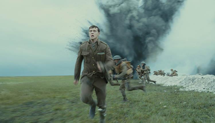 شخصیت اسکوفیلد در حال دویدن در میدان جنگ و انفجار بمب پشت سر او در فیلم 1917