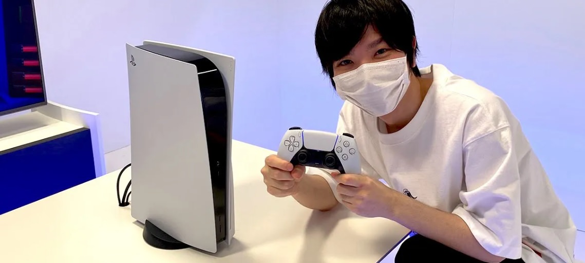 یک یوتیوبر ژاپنی در کنار کنسول پلی استیشن 5 سونی و دسته دوال سنس
