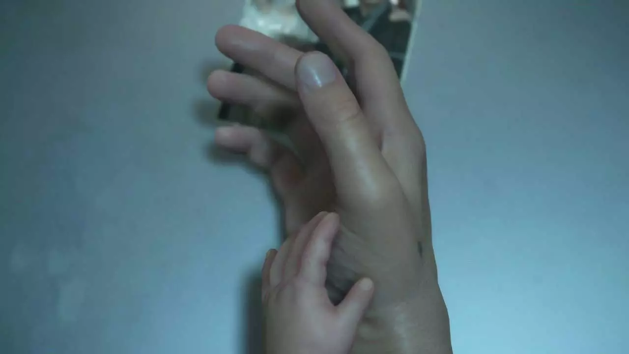 دست سم پورتر بریجز با بازی نورمن ریداس در دث استرندینگ کوجیما پروداکشنز کنار دست نوزاد روی عکس قدیمی