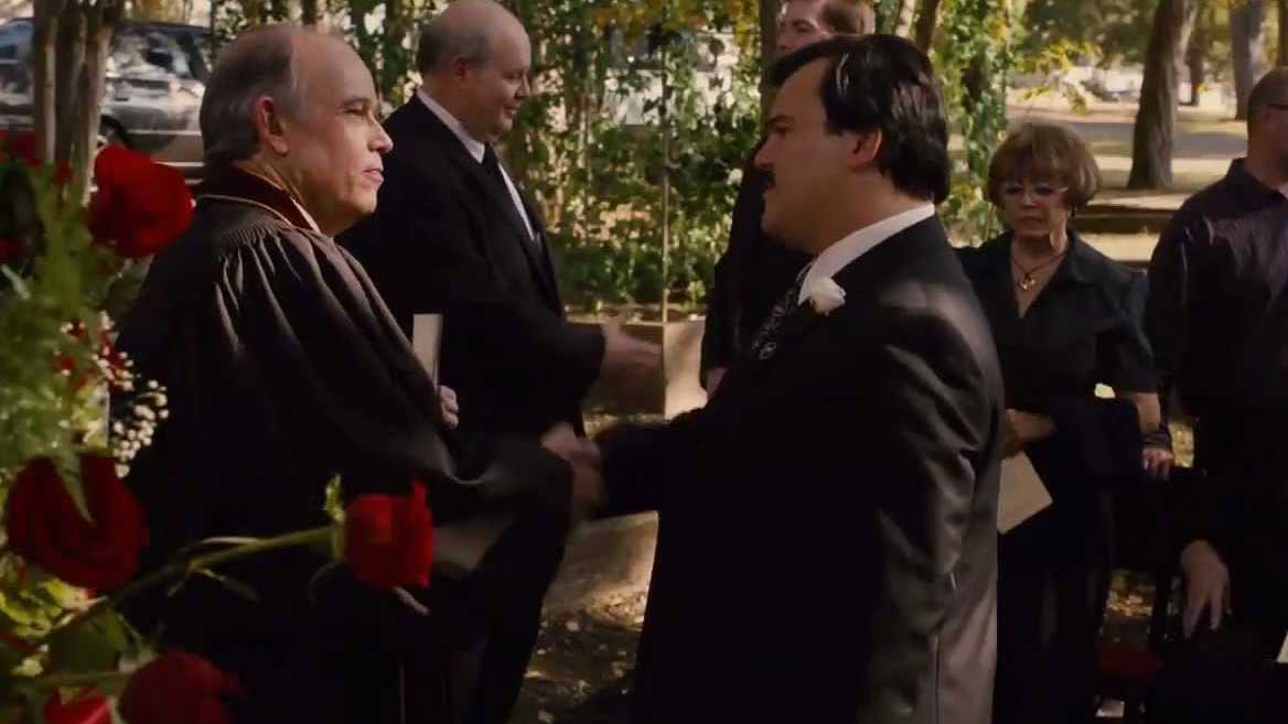 جک بلک در حال دست دادن با خانواده مرحوم و سیاه پوش در فیلم Bernie ریچارد لینک لیتر