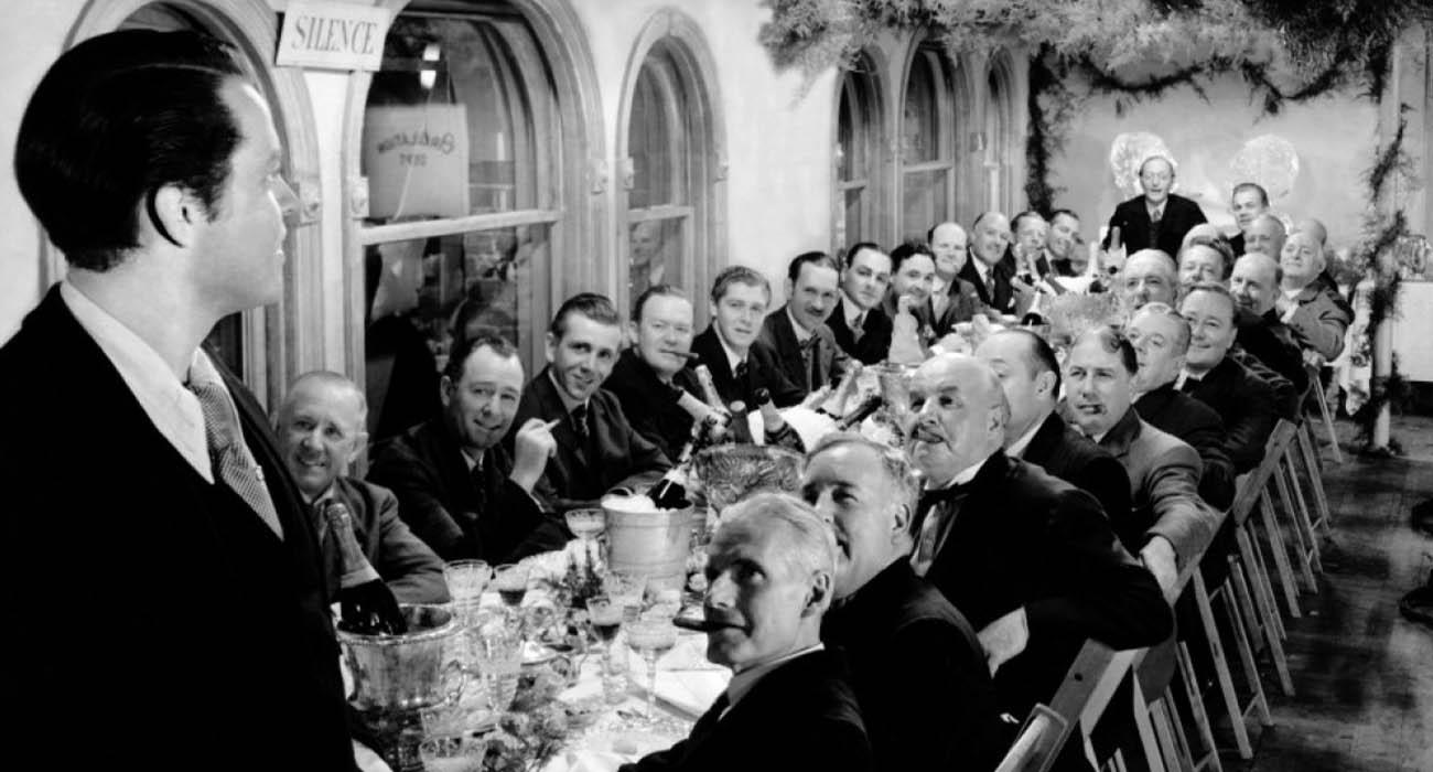 شخصیت‌های اصلی فیلم Citizen Kane دور یک میز بزرگ در حال صحبت کردن