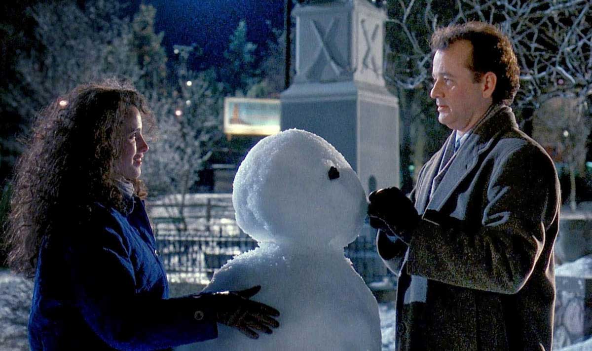 مرد و زن عاشق کنار آدم برفی در هوای سرد شهر فیلم Groundhog Day