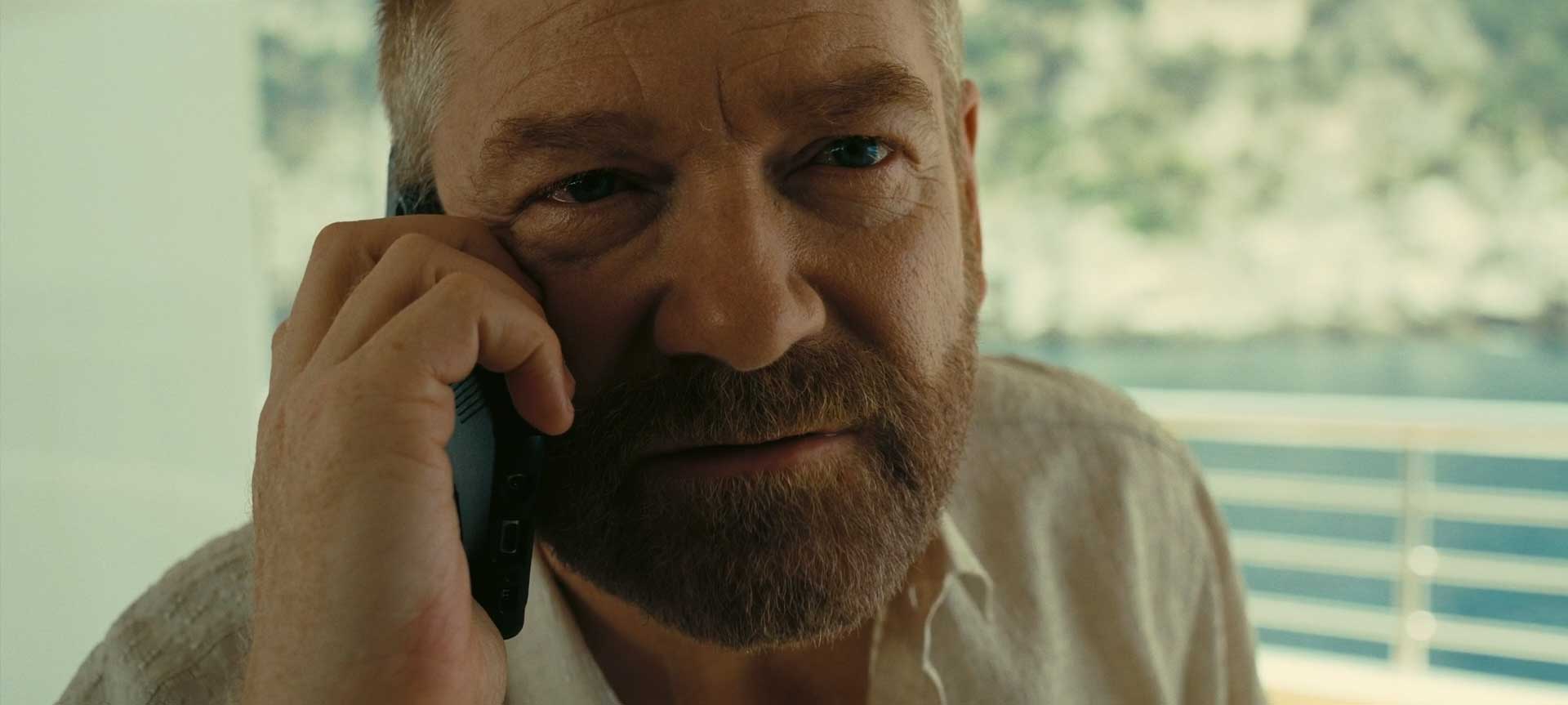 آندری سیتور با با نقش آفرینی کنت برانا مشغول حرف زدن با تلفن در فیلم Tenet نولان