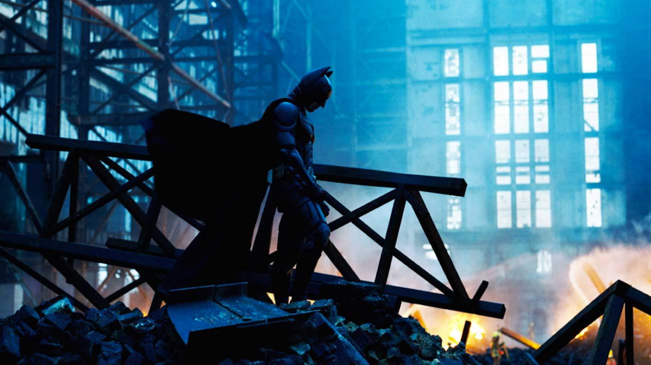 بتمن سرافکنده در فیلم The Dark Knight کریستوفر نولان مقابل آتش های در حال خاموش شدن
