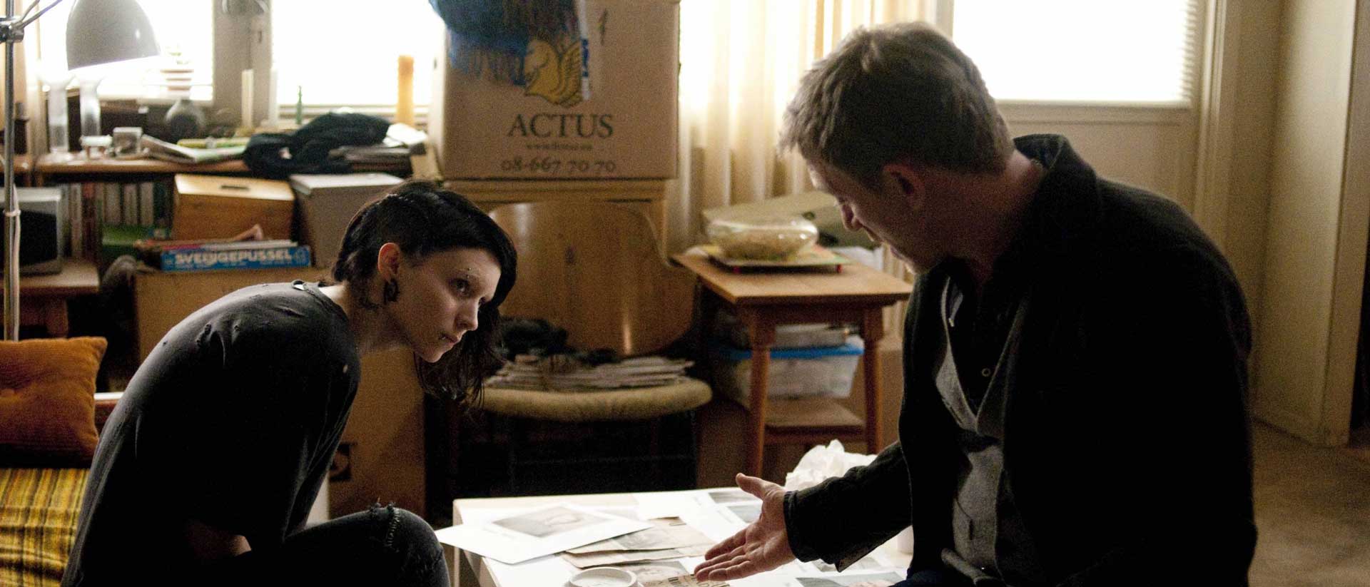 فیلم The Girl With The Dragon Tattoo و نگاه رونی مارا به دنیل کریگ داخل اتاق مشغول نگاه کردن به مدارک