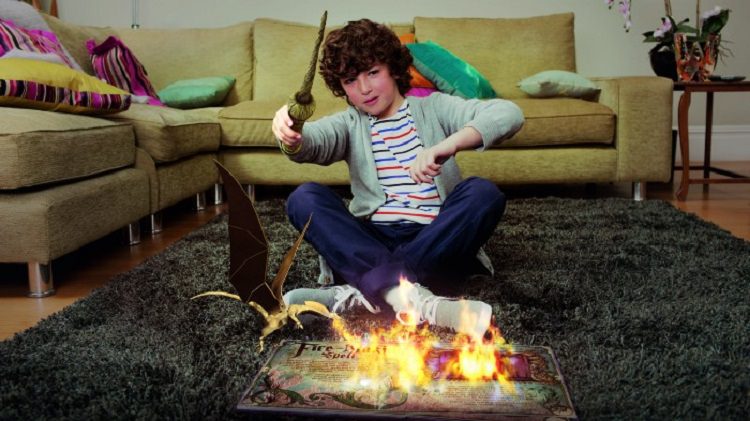 پسر نوجوان در تعامل با یک کتاب فانتزی دارای عناصر خیالی آتش و اژدها