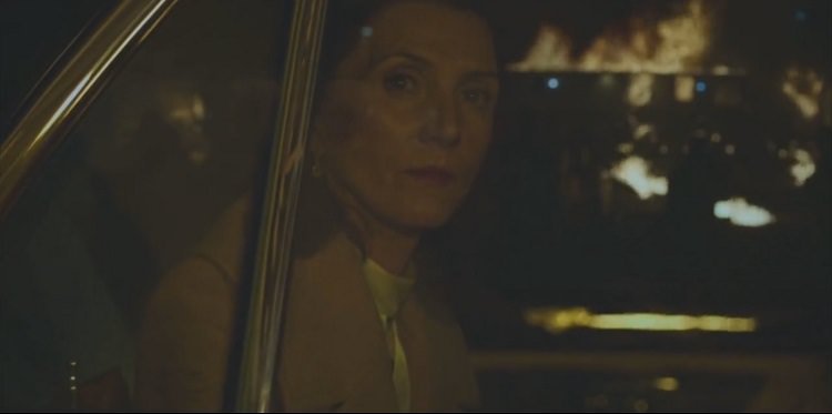 میشل فرلی در نقش ماریان در حال تماشای سوختن خودروی ون مشکی در سریال Gangs of London