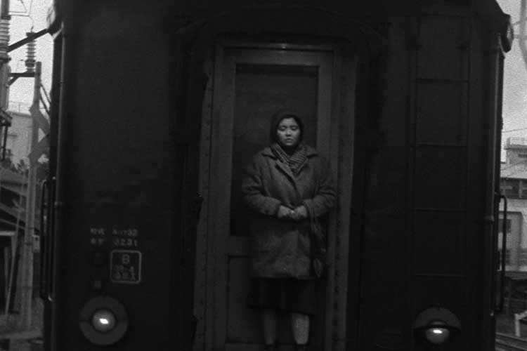 دختر تنها مقابل قطار در فیلم سیاه و سفید سینما ژاپن به اسم Akai satsui