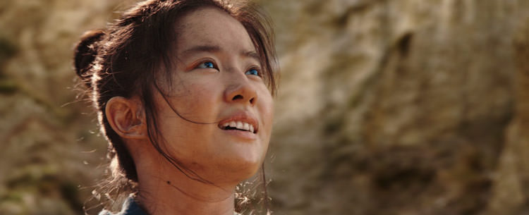 چهره شاد مولان مقابل صخره های کوهستانی در فیلم Mulan دیزنی
