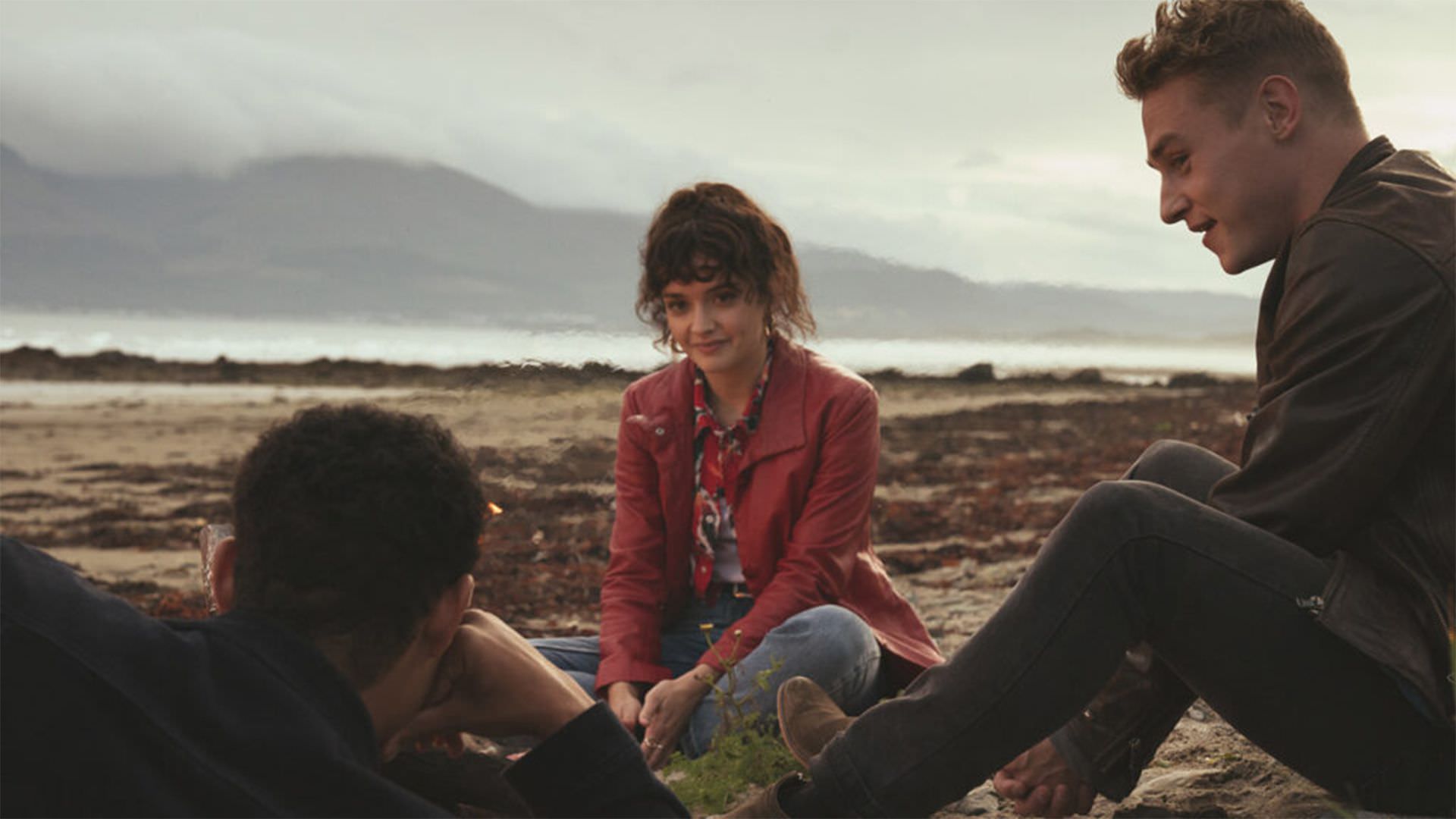 اولیویا کوک، بن هاردی و داریل مک‌کارمک در حال استراحت در کنار ساحل در فیلم Pixie