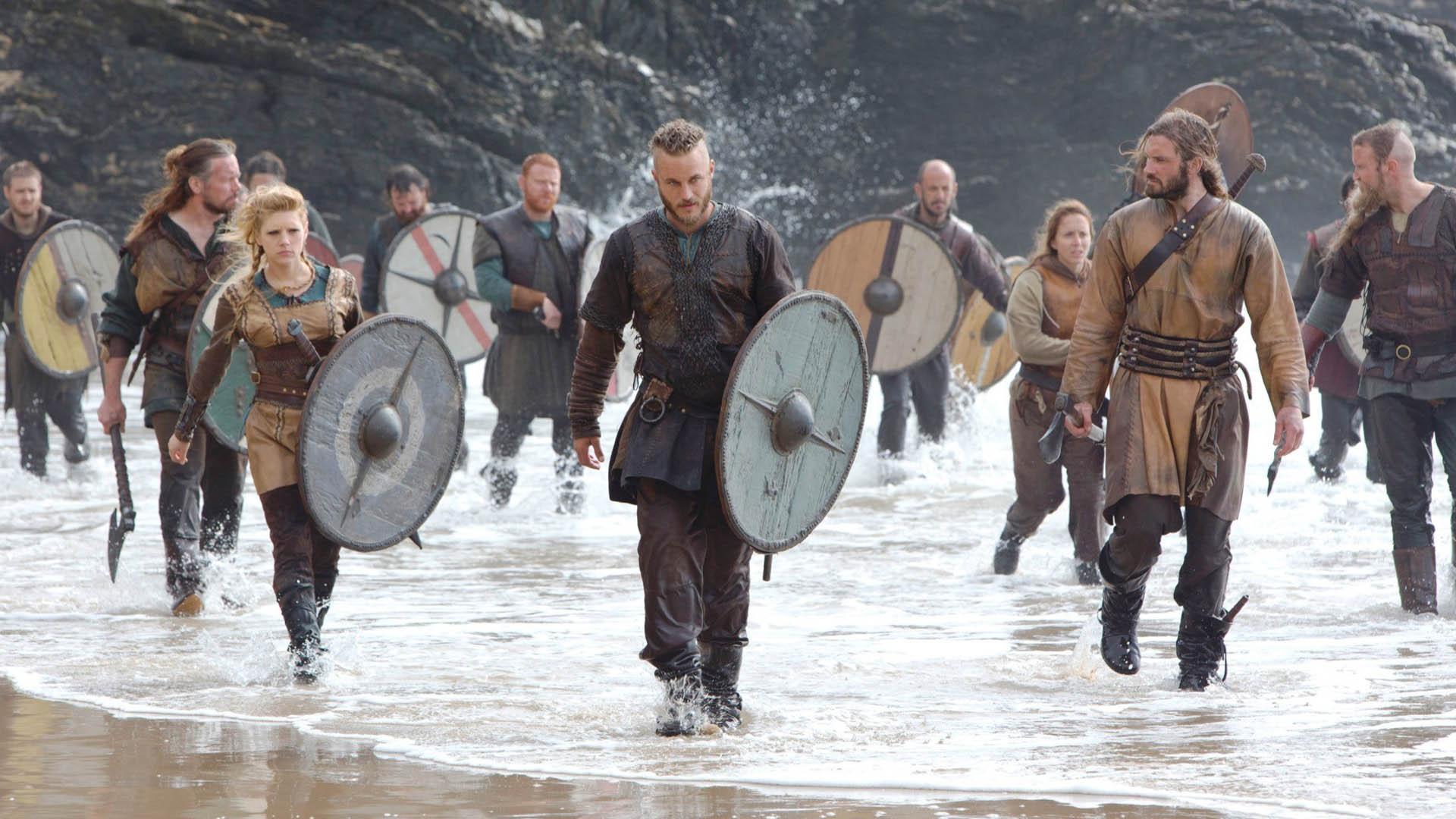 برخی از شخصیت‌های اصلی سریال vikings در کنار دریا همراه با اسلحه و سپرهای خود