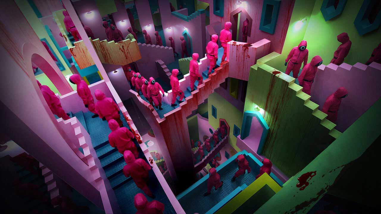 محیط بچگانه‌ی رنگارنگ و خون‌آلود با حضور افراد دارای لباس صورتی در سریال Squid Game