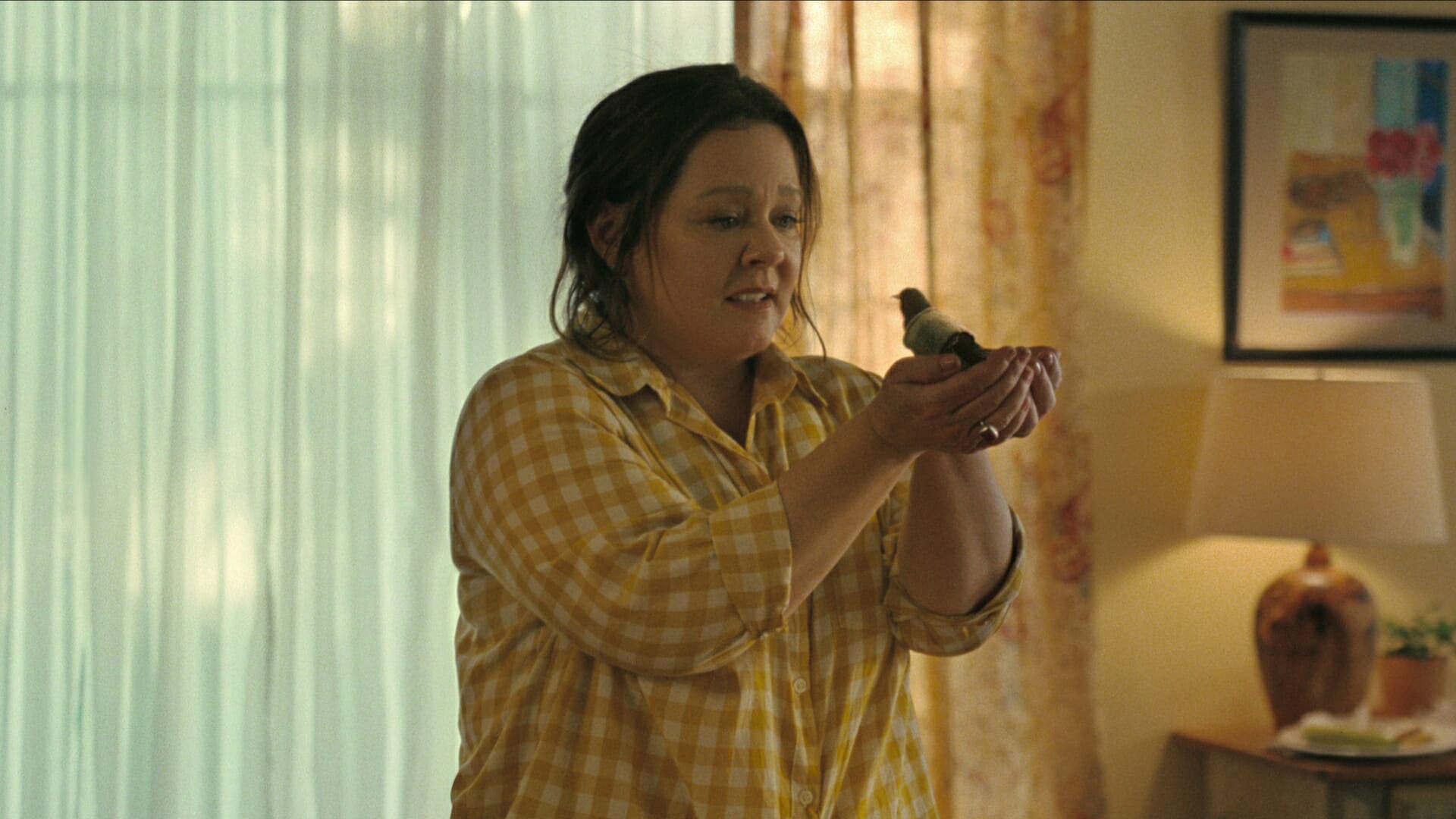 ملیسا مک کارتی در حال نگاه کردن به پرنده سار در دستانش در فیلم The Starling