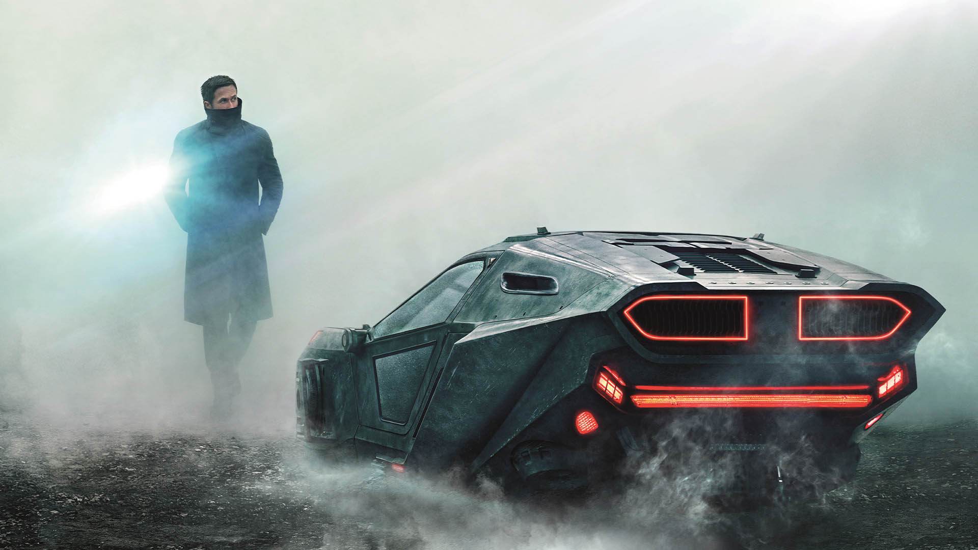 شخصیت کی با بازی رایان گاسلینگ درکنار ماشین خود در فیلم Blade Runner 2049