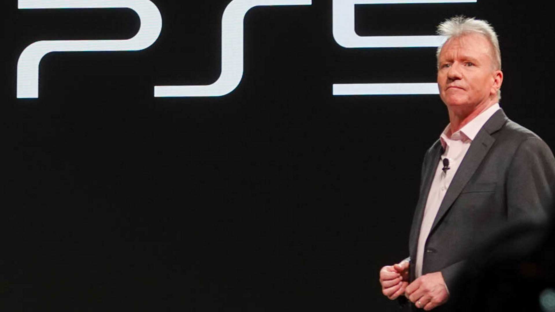 جیم رایان، رئیس و مدیرعامل بخش سرگرمی های تعاملی شرکت سونی در کنار لوگو کنسول PS5