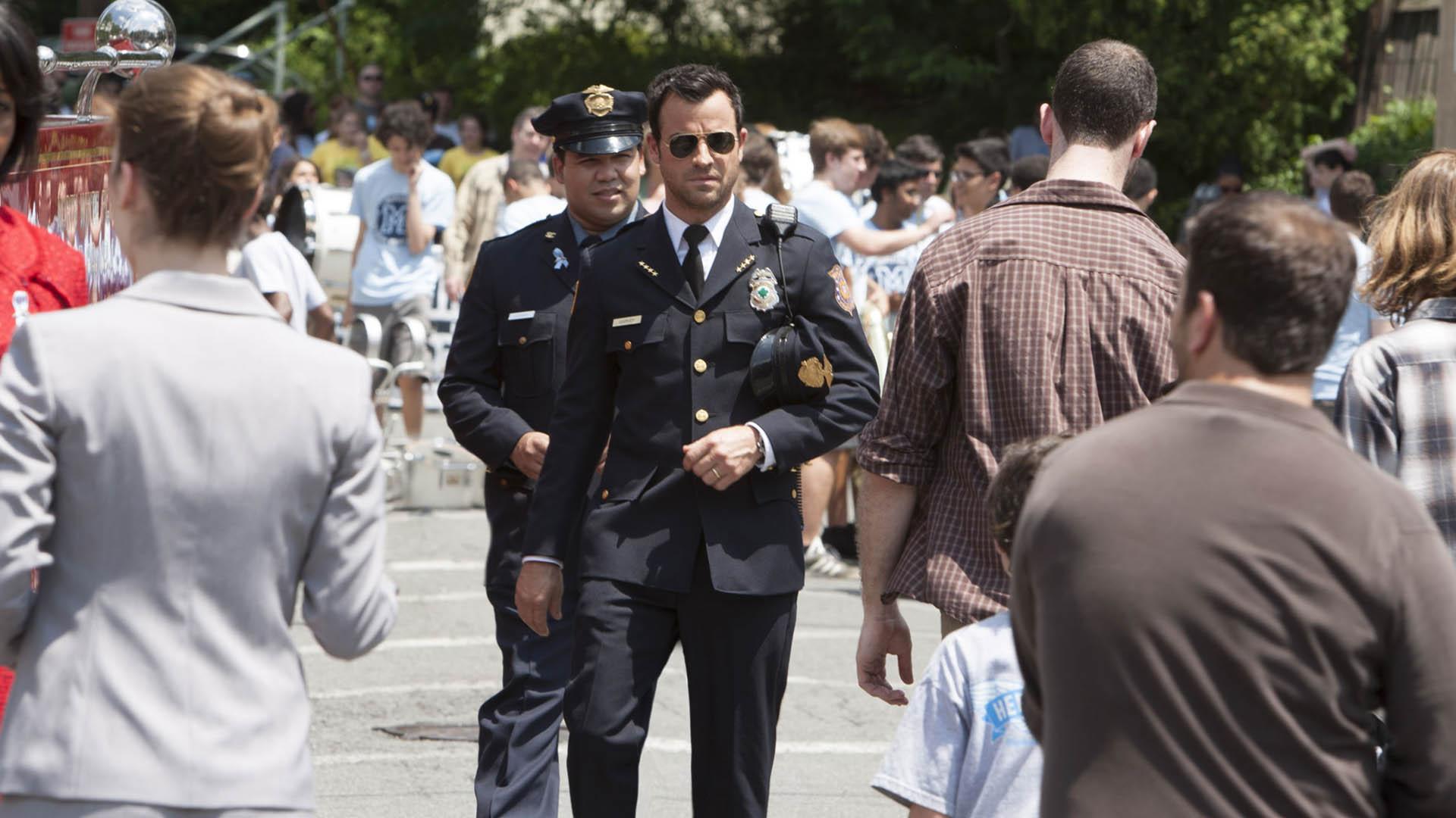 کوین گاروی با نقش‌آفرینی جاستین ثرو با لباس پلیس درمیان جمعیت در سریال The leftovers