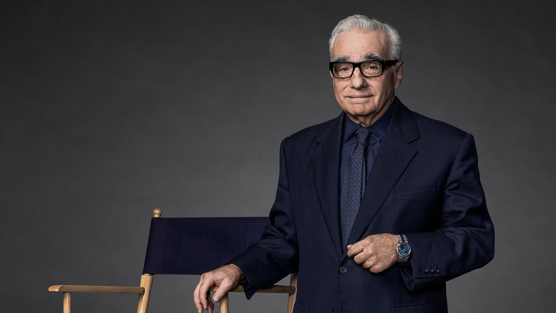 Sandalyenin yanında resmi bir takım elbise giymiş Martin Scorsese