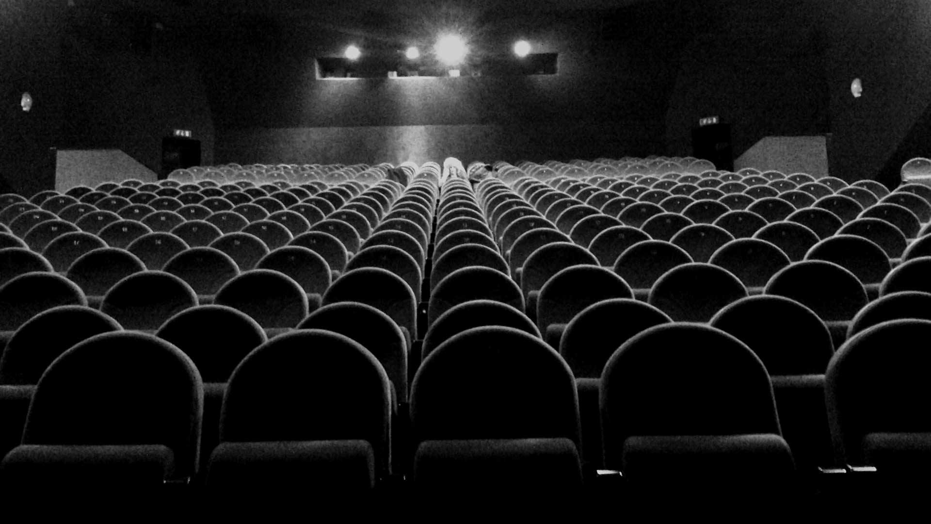 سالن خالی سینما و نور پروژکتور در حال تابیدن به صندلی ها