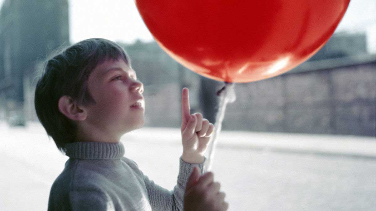 فیلم The Red Balloon از سینمای فرانسه و پسربچه مشغول نگه داشتن بادکنک قرمزرنگ