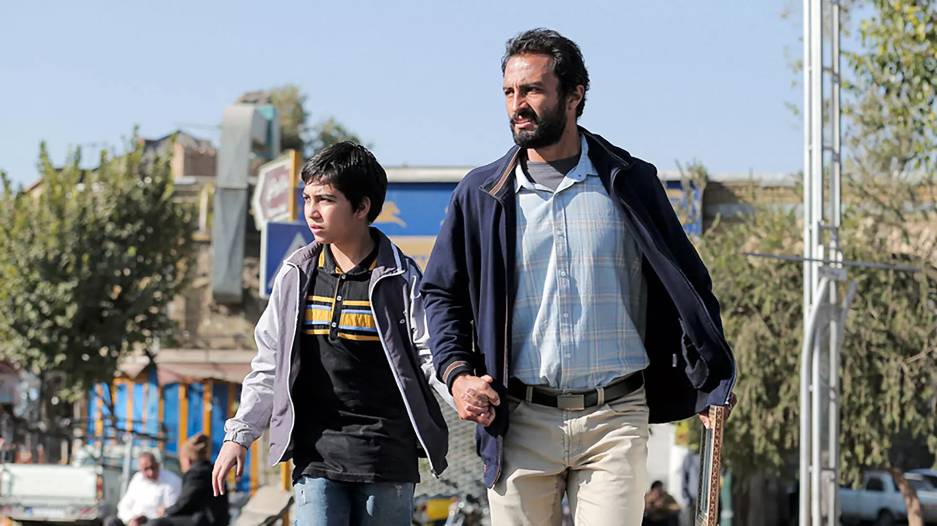 امیر جدیدی دست در دست پسربچه در فیلم قهرمان اصغر فرهادی