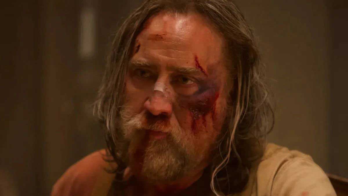 چهره خونی نیکلاس کیج با موهای بلند و لباس ساده در فیلم خوک سال ۲۰۲۱ میلادی