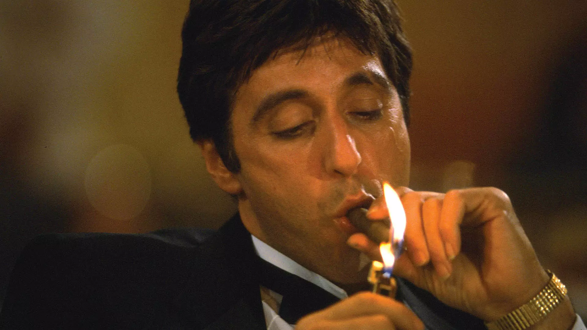 شخصیت تونی مونتانا درحال روشن کردن سیگار خود در فیلم scarface 