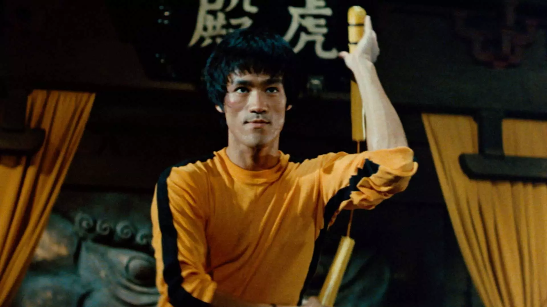 بروس لی با لباس زرد و سیاه معروف مشغول انجام حرکات رزمی در فیلم Game of Death
