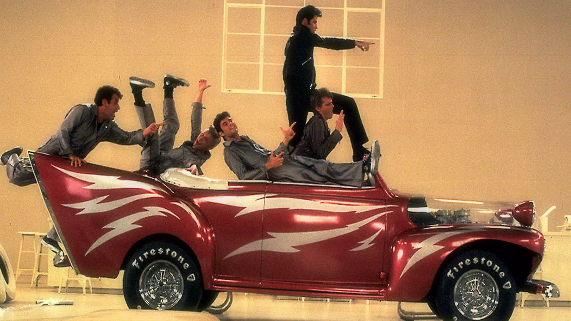 جان تراولتا و سایر بازیگران فیلم Grease روی یک ماشین