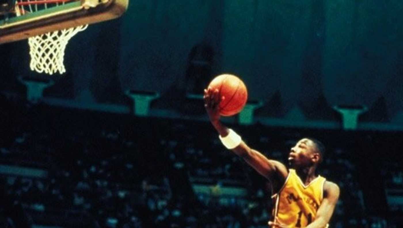 بازیکن بسکتبال با لباس زرد مشغول تلاش برای انداختن توپ داخل سبد در فیلم Hoop Dreams
