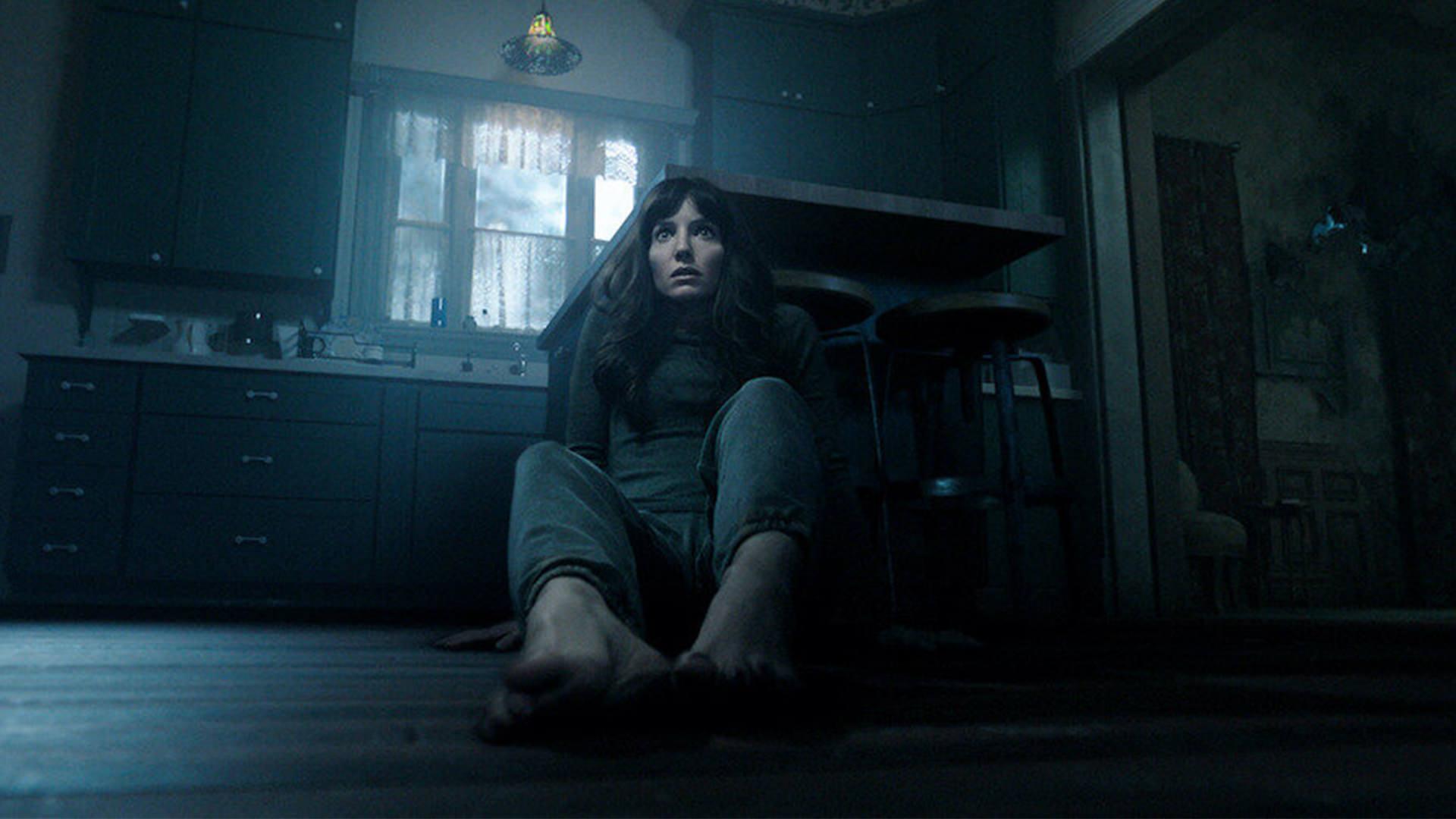آنابل والیس در نقش مدیسون نشسته روی زمین در اتاقی تاریک در فیلم Malignant