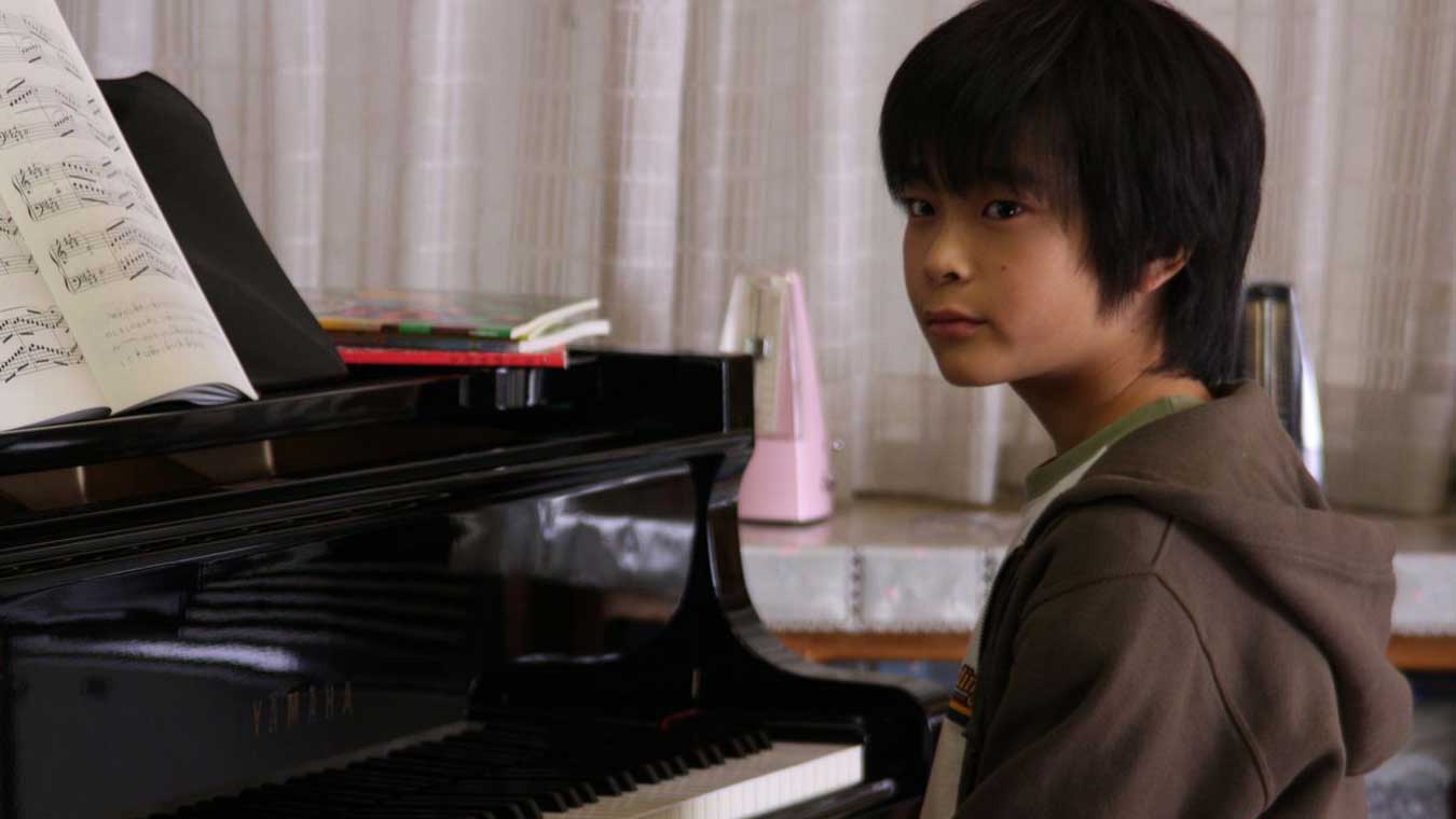 پسر نوجوان ژاپنی مقابل پیانو در فیلم Tokyo Sonata