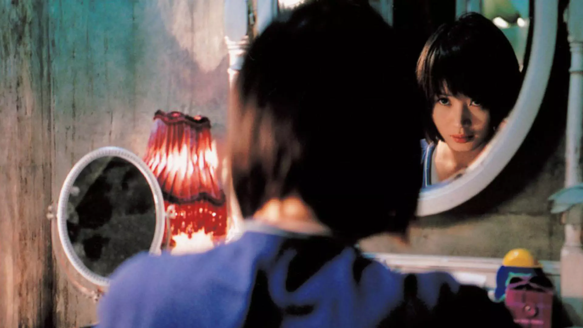 کیم هه سو در حال نگاه کردن به خود در آینه در فیلم The Red Shoes