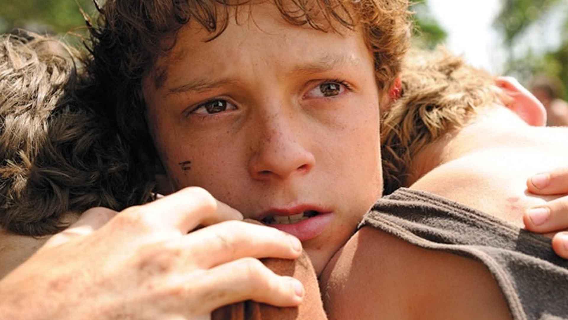 تام هالند در فیلم The Impossible دو برادر خود را بغل کرده است