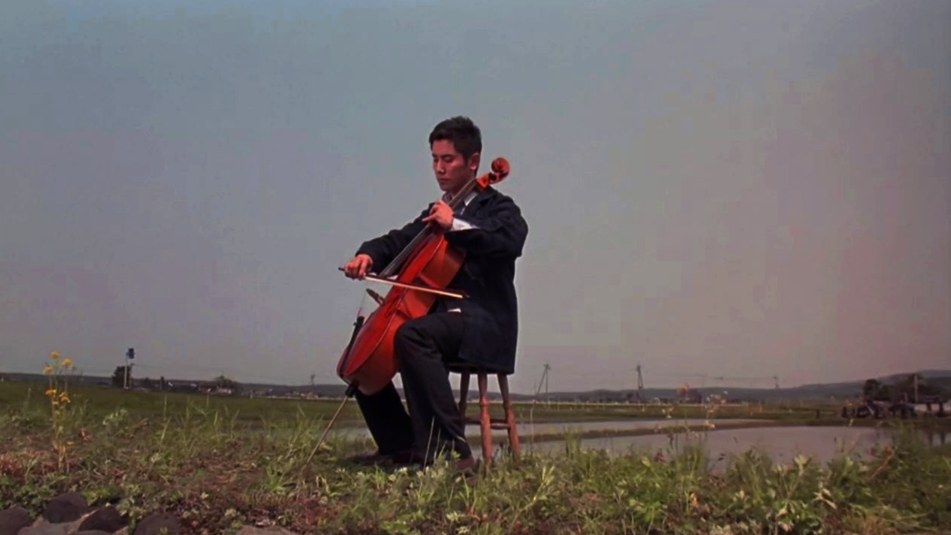 دایگو در حال نواختن ویولون سل در فیلم Departures