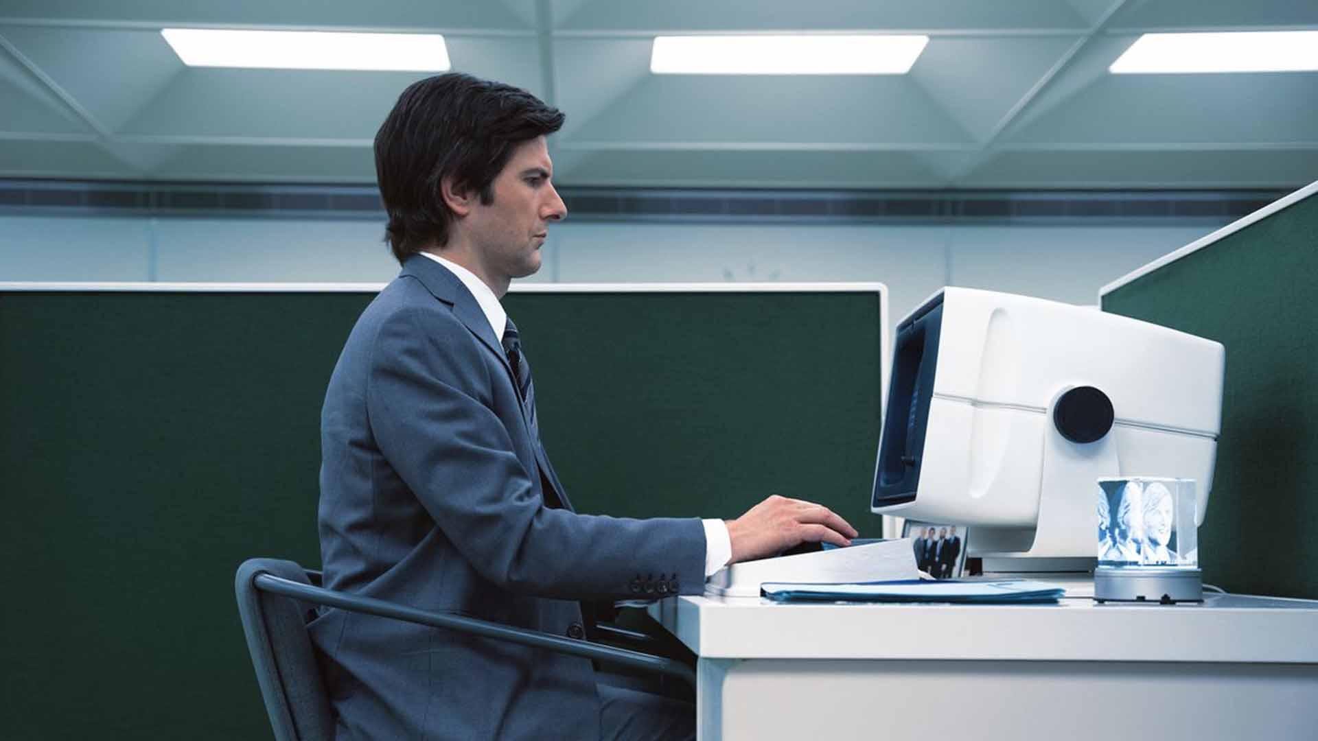 آدام اسکات با یک کامپیوتر شرکتی در Severance کار می کند