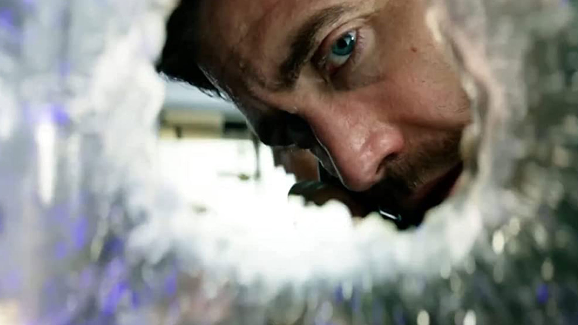جینلهال در حال نگاه کردن به سوراخ شیشه در فیلم آمبولانس