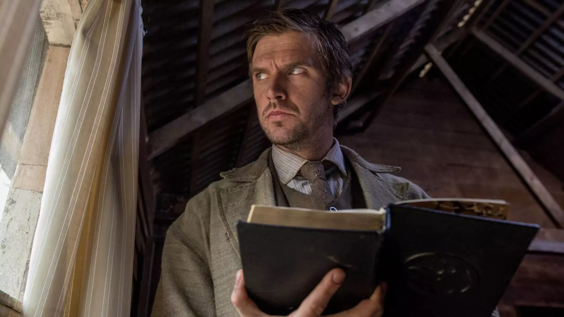 دن استیونز در فیلم apostle همراه یک کتاب به بیرون از پنجره نگاه می‌کند