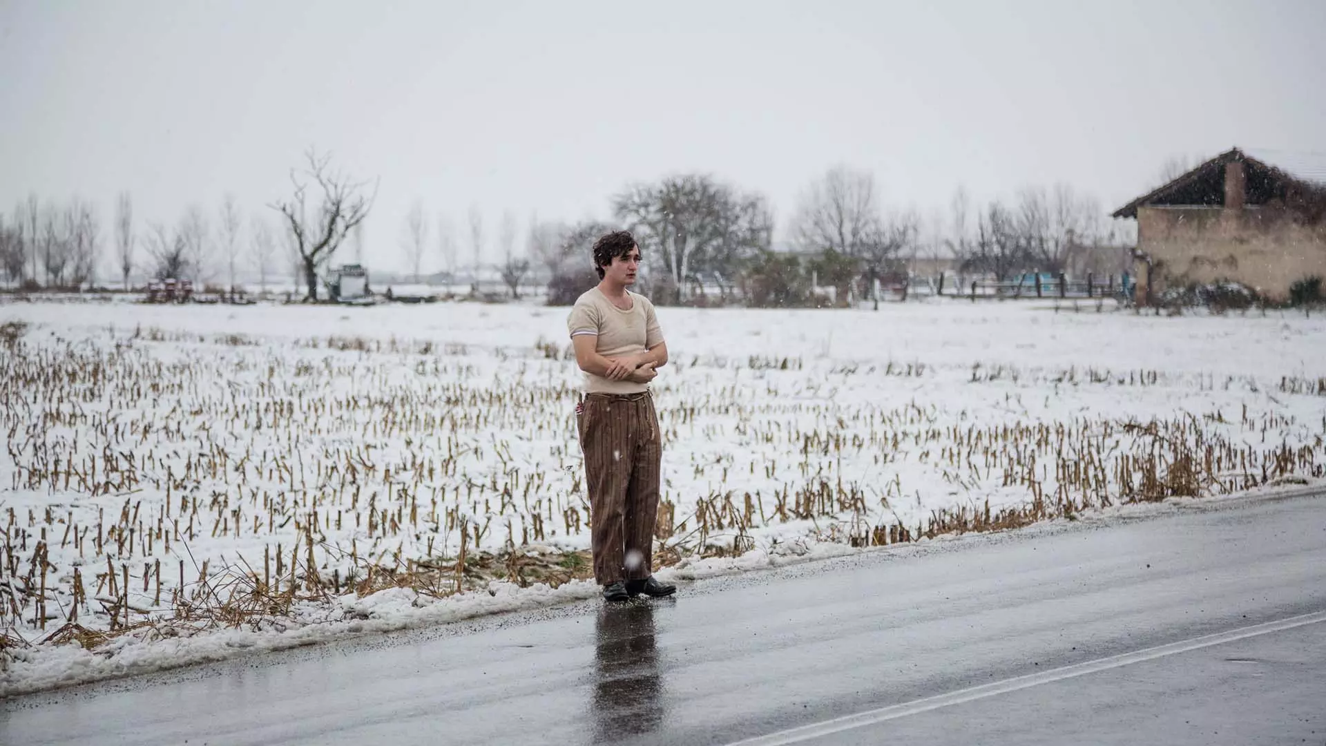 آدریانو تاردیولو در فیلم Happy as Lazzaro کنار جاده ایستاده است