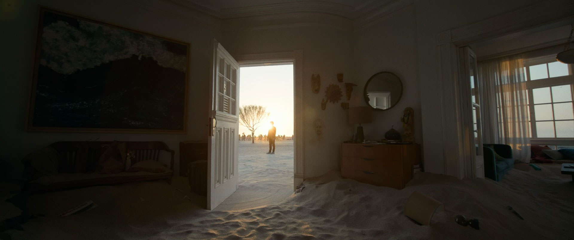 خانه‌ای پر از ماسه با دری باز که بیرونش مردی قابل‌رویت است و از طریقش نور به داخل خانه می‌تابد در عکسی رسمی از فیلم باردو به کارگردانی الخاندرو گونسالس اینیاریتو