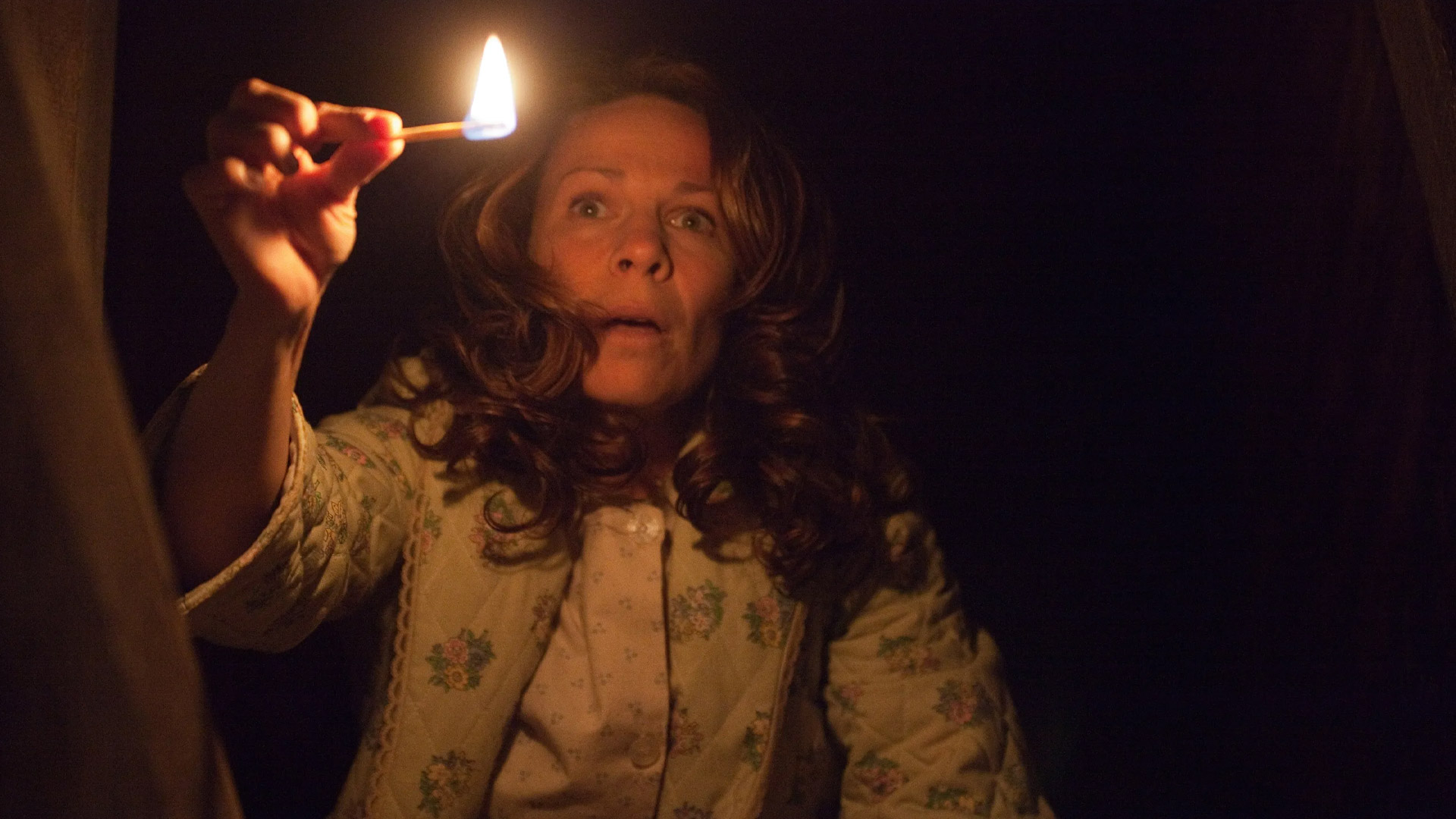 کرولین پرون با کبریت روشن در زیرزمین فیلم کانجورینگ