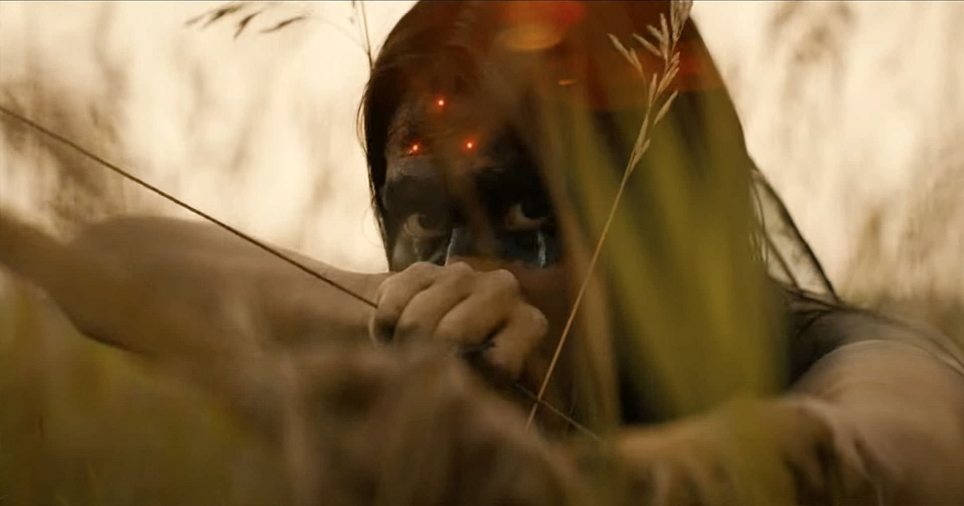 سرخ‌پوستی که کمانی را در میانه‌ی علف‌زار نشانه رفته در صحنه‌ای از فیلم طعمه