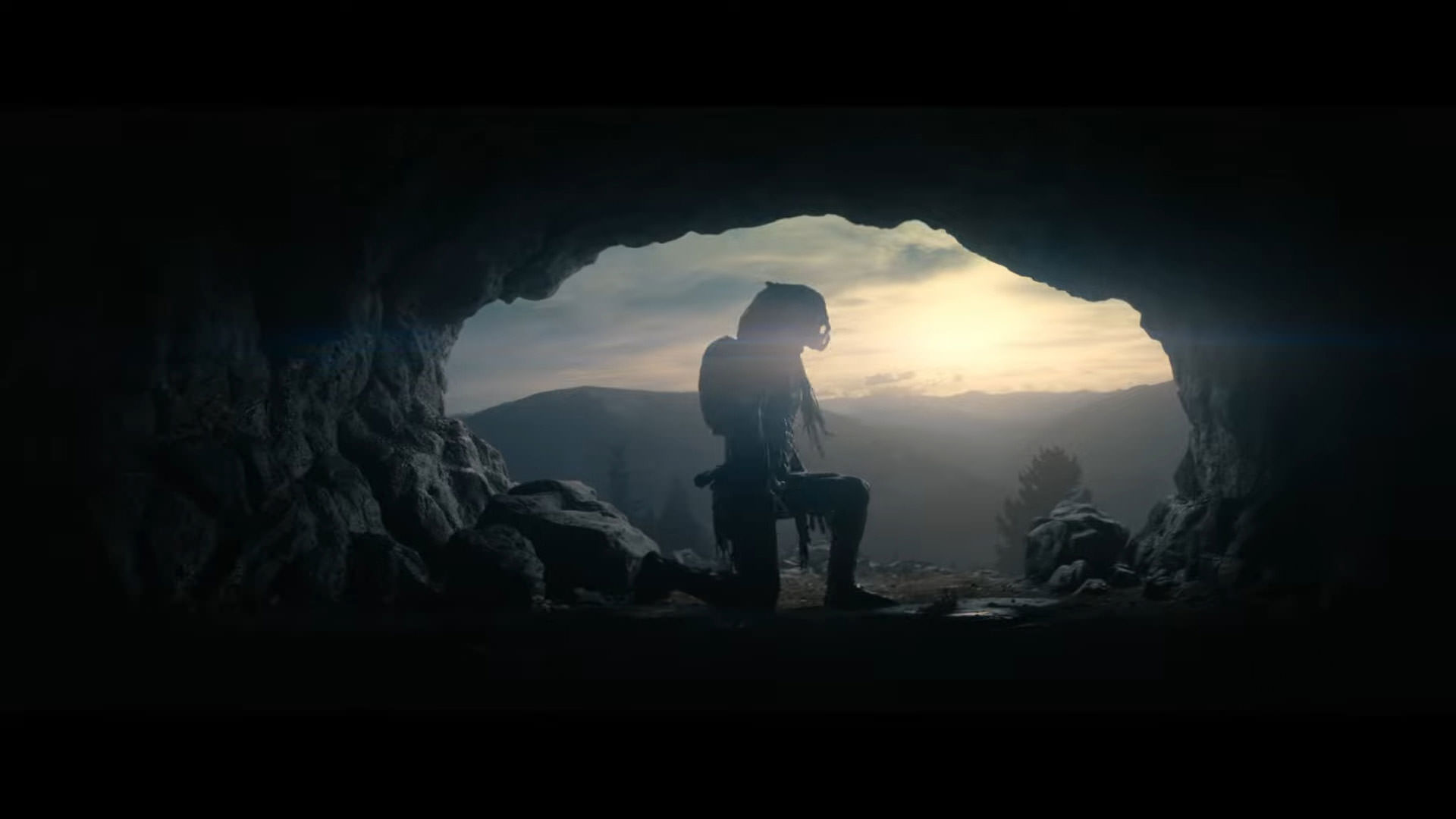 Prey filminden arkadan aydınlatmalı bir sahnede bir mağaranın içindeki yırtıcı bir canavar