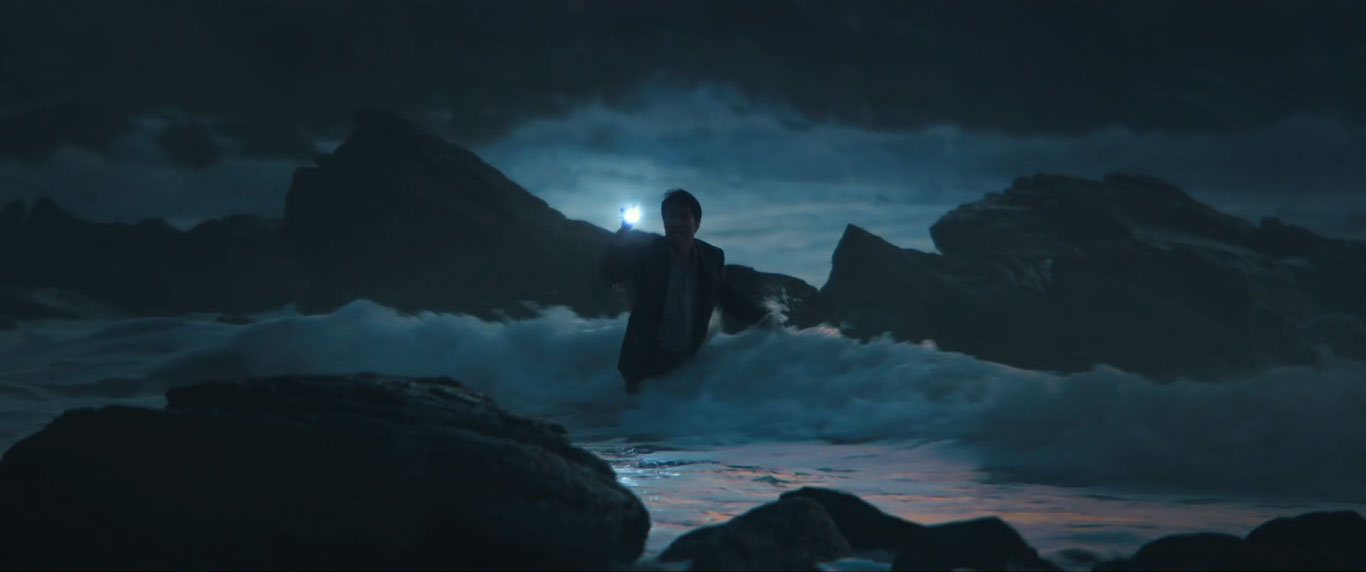 پارک هائه-ایل چراغ قوه به دست میان امواج دریا در نمایی از فیلم عزم رفتن به کارگردانی پارک چان ووک 