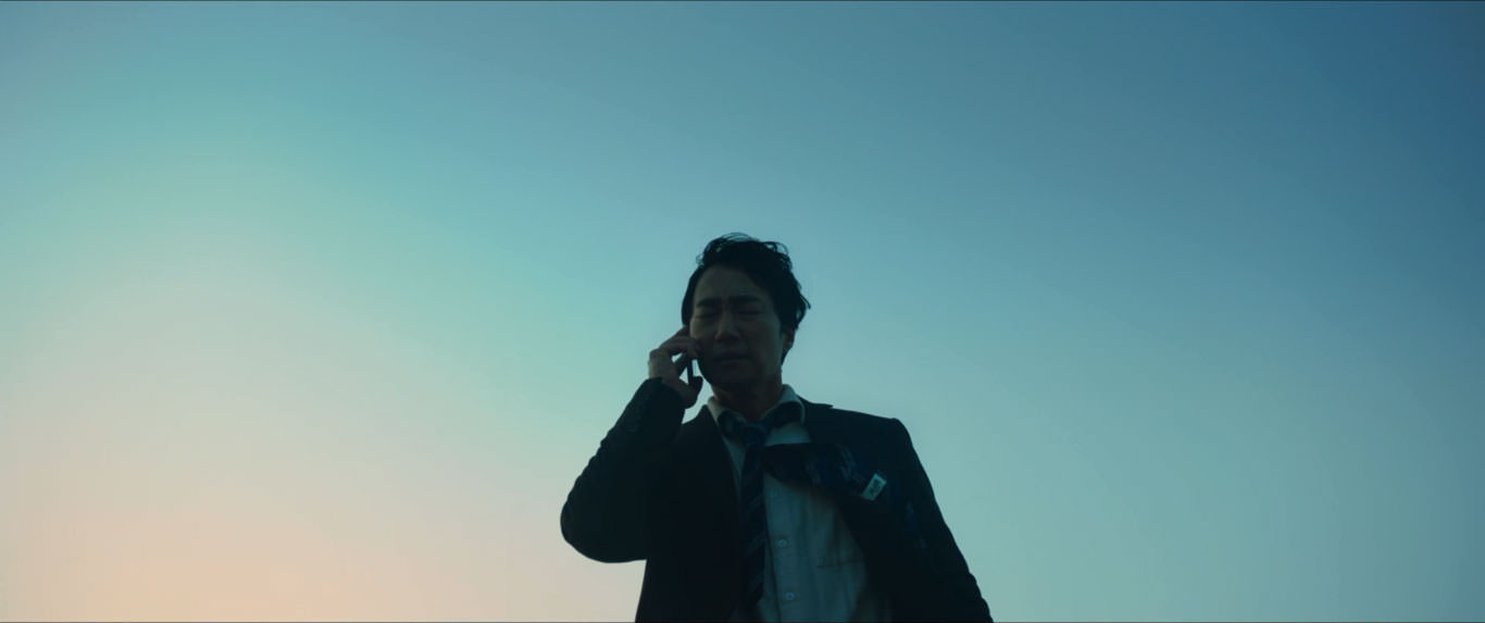 پارک هائه-ایل از زاویه‌ی پایین با زمینه‌ی آسمان در حال گوش دادن به صدای تلفن همراه در نمایی از فیلم عزم رفتن به کارگردانی پارک چان ووک