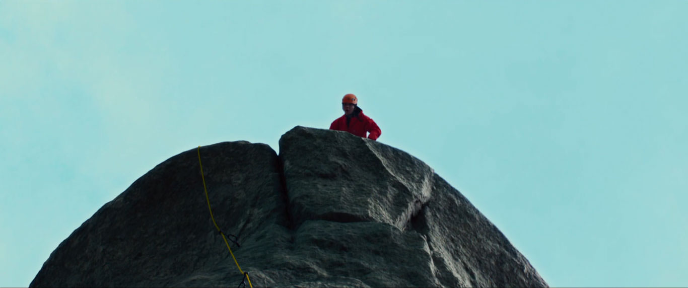 تانگ وی با کاپشن قرمز بالای یک صخره در نمایی از فیلم عزم رفتن به کارگردانی پارک چان ووک