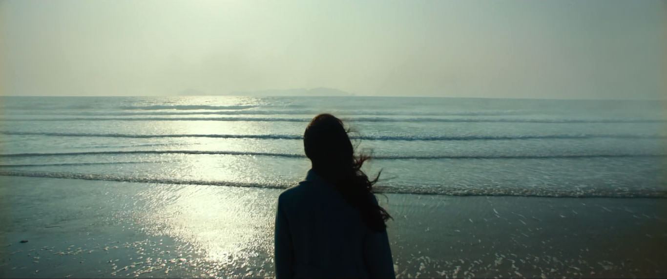 تانگ وی پشت به دوربین مقابل دریا در نمایی از فیلم عزم رفتن به کارگردانی پارک چان ووک