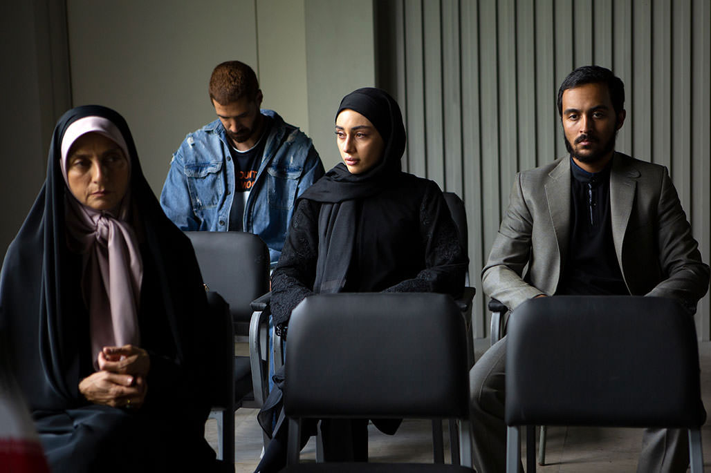 Yesna Mirtahmasab, Tarlan Parvaneh, Roya Javednia et Irfan Naseri assis dans une pièce du bureau du procureur dans une scène du film Alafzar réalisé par Kazem Daneshi.