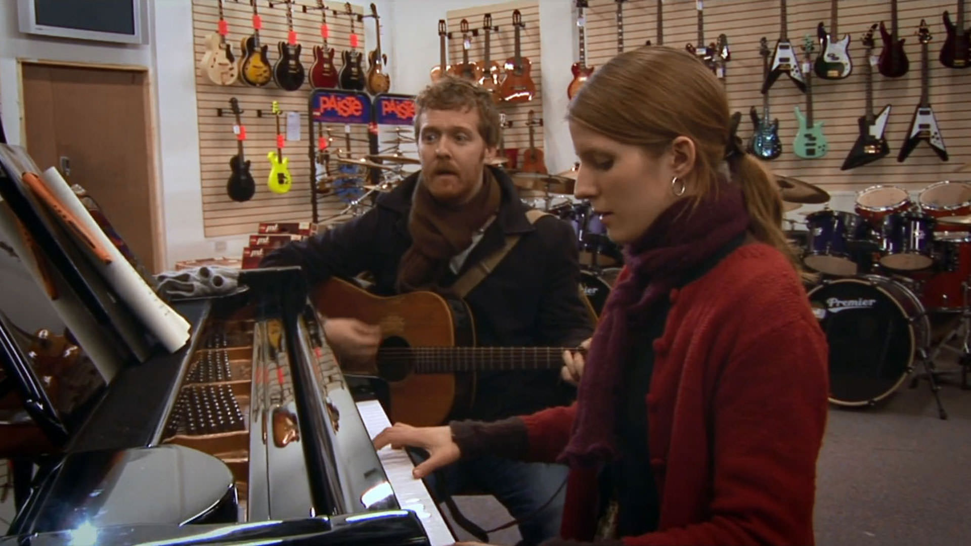 گلن هنسارد در حال نواختن گیتار در کنار مارکتا ایرگلووا که پیانو می‌نوازد داخل یک فروشگاه آلات موسیقی در نمایی از فیلم یک‌بار به کارگردانی جان کارنی