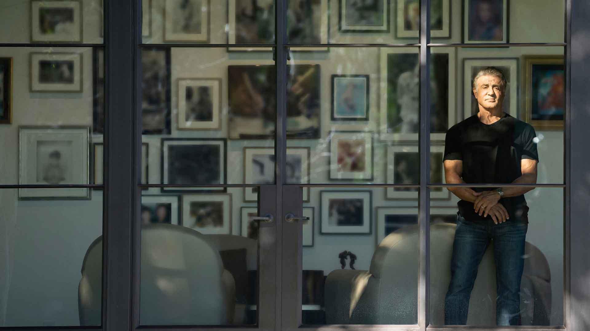 سیلوستر استالونه در حال نگاه کردن به بیرون از خانه در مستند Sly