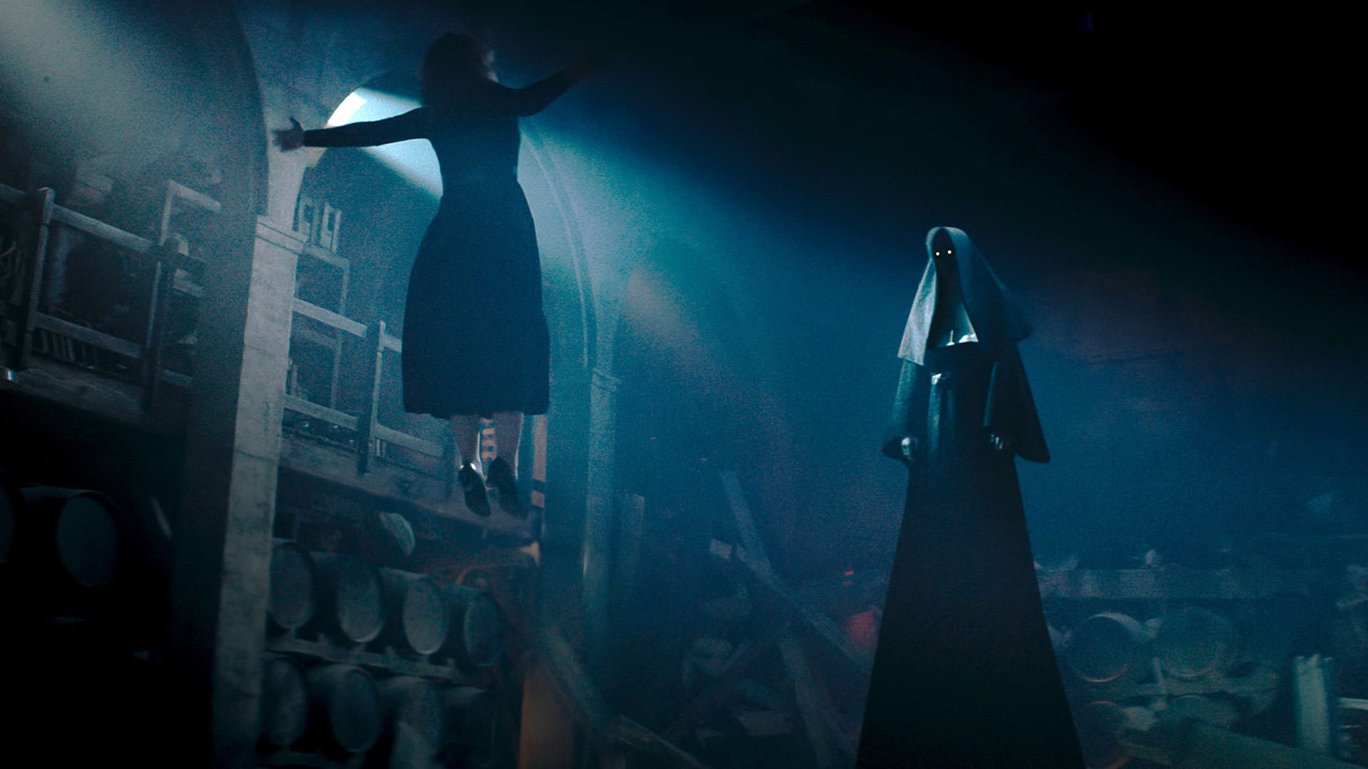 یک راهبه‌ی شیطانی قد بلند راهبه‌ی دیگری را داخل هوا معلق نگه داشته است در نمایی از فیلم راهبه ۲ به کارگردانی مایکل چاوز
